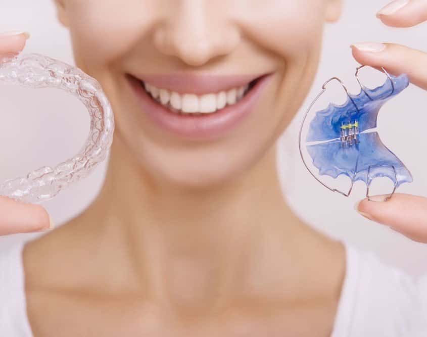 adult-holding-invisalign-braces-and-retainer adult-holding-invisalign-braces-and-retainer