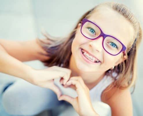 kid-with-braces-making-a-heart kid-with-braces-making-a-heart